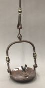 An early 19th century wrought iron lenticular lamp