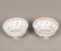 A pair of Chinese porcelain tea bowls, decorated with iron red lotus strapwork. 9 cm diameter.