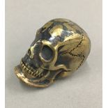 A brass skull vesta