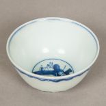 A Chinese blue and white porcelain tea bowl, decorated with incised stylised waves,
