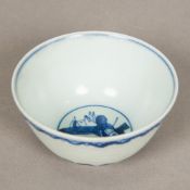 A Chinese blue and white porcelain tea bowl, decorated with incised stylised waves,