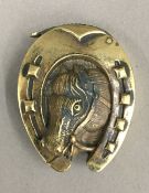 A brass horseshoe vesta