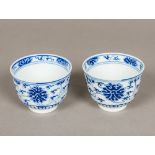 A pair of Chinese blue and white porcelain tea bowls, both decorated with lotus strapwork,