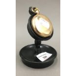 A gold plated pocket watch on stand