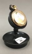 A gold plated pocket watch on stand