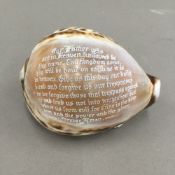 A large 19th century cowrie shell engraved with the Lord's Prayer