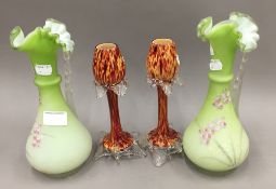 A pair of Victorian florally decorated green satin glass ewers and a pair of glass vases
