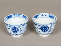 A pair of Chinese blue and white porcelain tea bowls, both decorated with lotus strapwork,