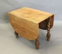 An early 20th century oak barley twist drop leaf table