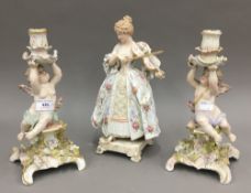 A pair of Continental porcelain candlesticks and a Continental porcelain figurine of a musician