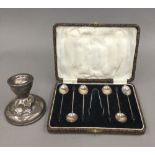 A cased set of silver coffee spoons and a silver candlestick