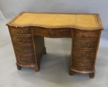 A walnut leather inset pedestal desk