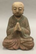 A Chinese wooden carving of a praying man