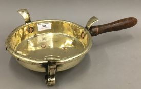 A 19th century wooden handled brass pan