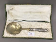 An unmarked Continental silver and silver gilt boxed strawberry spoon