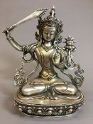 A Sino-Tibetan white metal deity Typically worked seated on a lotus plinth. 21.5 cm high.