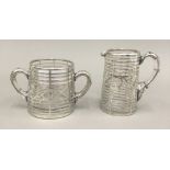 A glass and sterling silver overlay cream jug and sugar bowl