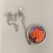 A silver and enamel coin pendant