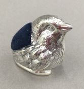 A silver pin cushion in the form of a bird