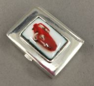 A silver pill box depicting a car