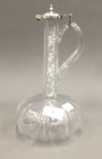 A glass claret jug with an unmarked silver lid