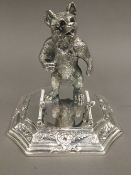 A silver plated stand modelled with a bear