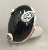 A silver and black stone ring