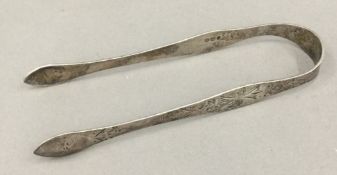 A pair of bright cut silver tongs