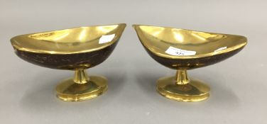 A pair of pedestal bonbon dishes formed from brass mounted coconuts