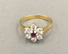 An 18 ct gold, diamond and ruby flower head ring (2.