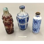 Two Chinese cameo glass snuff bottles and another blue and white porcelain snuff bottle