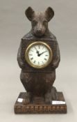 A carved wooden bear form clock