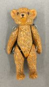 A small cold painted articulated teddy bear