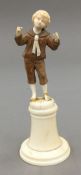 A 19th century carved ivory and wooden figure of a boy