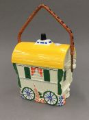 A biscuit barrel formed as a gypsy caravan