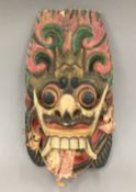 An Eastern painted carved wooden mask