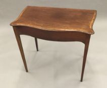 A mahogany serpentine work table