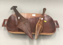 Two South Seas wood sword shaped hand clubs and a rectangular carved wood South Seas bowl