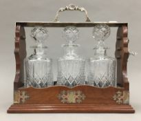 A silver plate moulded mahogany three bottle tantalus