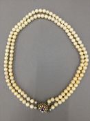 A simulated pearl necklace with a 9 ct gold clasp