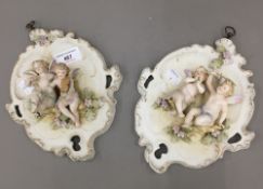 A pair of Continental porcelain cherub moulded wall plaques