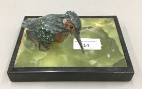 A cold painted bronze model of a kingfisher mounted on an onyx base