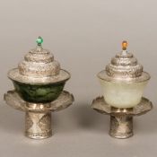 Two Sino-Tibetan carved jade bowls on white metal stands with covers One bowl spinach green,