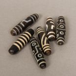 Six Tibetan Zhi beads Each of typical form, variously decorated. The largest 5.75 cm long.