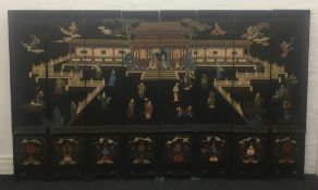 An early 20th century Chinese eight panel lacquered screen Decorated with various figures before a