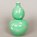 A Chinese porcelain double gourd vase Decorated with floral sprays and butterflies on a green