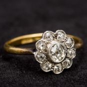 An 18 ct gold and diamond flowerhead set ring The central stone spreading to approximately 0.