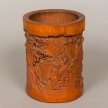 A Chinese carved bamboo brush pot Decorated in the round with figures in various pursuits amongst a