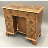 An 18th century style walnut kneehole desk The moulded crossbanded rectangular top above an