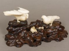 A Japanese Meiji period carved ivory and hardwood animalier group Formed as a birds nest,